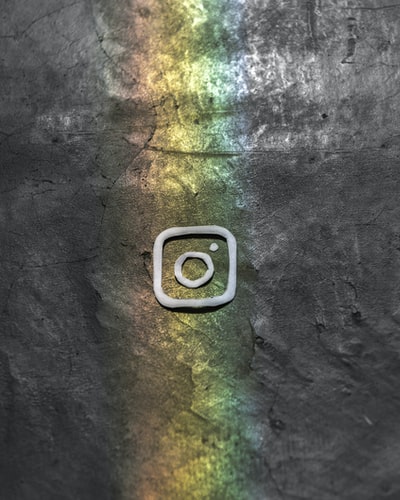 logo de instagram con arcoiris sobre fondo gris