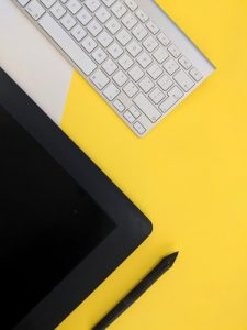 fondo amarillo , teclado y ipad. conceptos básicos del marketing digital